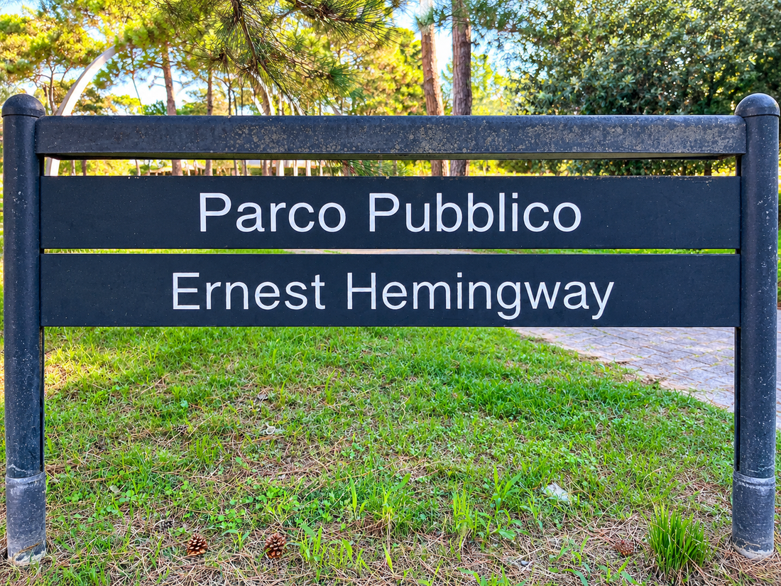 Schild am Eingang des Parco Pubblico Ernest Hemingway in Lignano Pineta, umgeben von Pinien und Grünflächen. Foto: Martina Meier